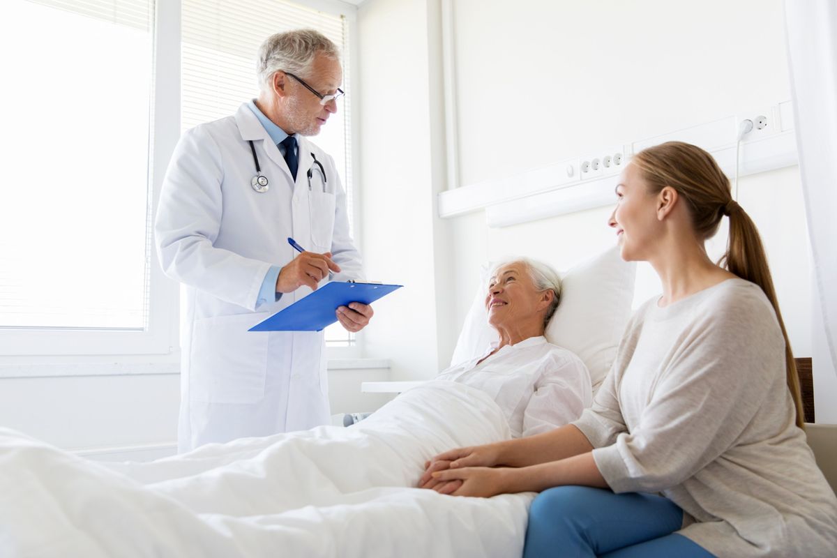 A hospitalist reviewing care with an older patient and her daughter